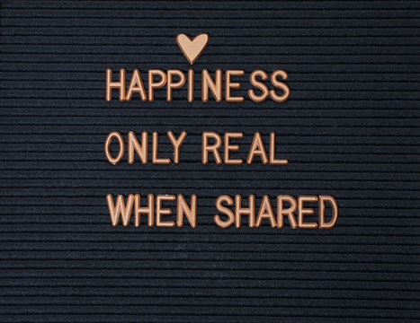 Happiness is only real when shared text on black board