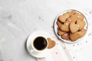 Delicious homemade cookie hearts with a cup of coffee on a light background. Top view. Place for text.