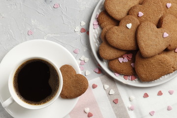Delicious homemade cookie hearts with a cup of coffee on a light background. Top view. Place for text.