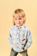 Funny child.fashionable little boy in a plaid shirt and jeans .fashion children In the studio on a light background.
