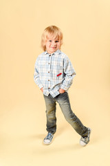 Funny child.fashionable little boy in a plaid shirt and jeans .fashion children In the studio on a light background.