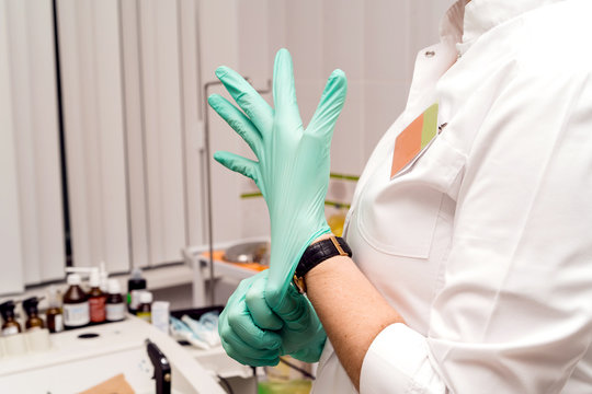 Medical procedures in the office of the ENT specialist. Otorhinolaryngologist doctor pediatrician therapist. Doctor putting rubber gloves on hands. Family reception at a private clinic