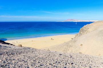 View of beautiful Playa de la Cera beach, from above, blue sea, yellow sand, cliffs. Papagayo, Playa Blanca, Lanzarote, Canary Islands, selective focus