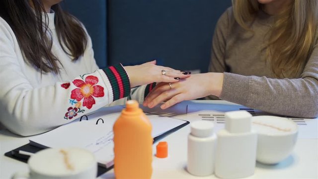 Female Seller Demonstrating New Body Cream to a Customer and Applying it on her Hand. Cosmetics Consulting, Direct Sale and Multi Level Marketing Concept