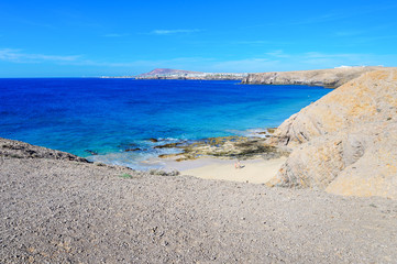 Fototapeta na wymiar View of beautiful Playa de la Cera beach, from above, blue sea, yellow sand, cliffs. Papagayo, Playa Blanca, Lanzarote, Canary Islands, selective focus