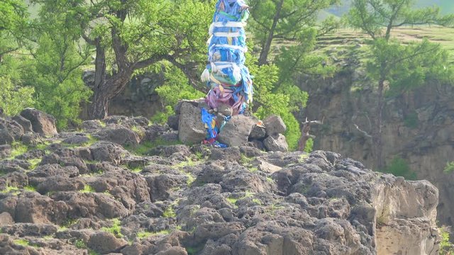 Ovoo is Khata khatag khatas or hatag is a traditional ceremonial scarf in tengrism and Tibetan Buddhism culture. Obo is sacred stone heaps used as altars or shrines. Shaman shamanism blue tie worship.