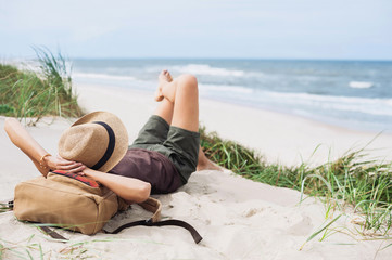 Young woman resting by the sea. Girl lying down on the beach. Enjoying life, summer lifestyle,...