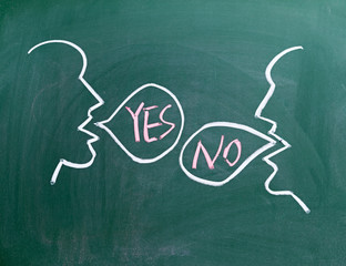 two faces on blackboard one saying no and the other one yes