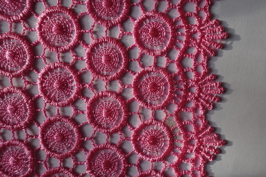 Vertical edge of bright pink crochet lace