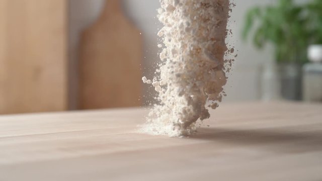 Pouring flour onto a cooking table. Slow Motion. 