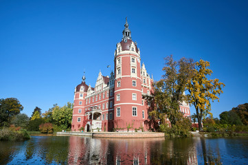 New Castle and moat in the park Muskauer  during autumn in Germany.
