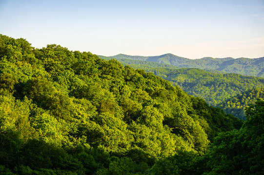 View of Caucasian mountains from highest point on mountain pass. Mountain road passes through cliffs. Away green slopes of mountains. There is place for your text. Nature concept for design.