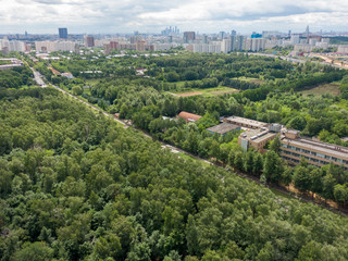 A large green park aerial view, in the background the city and tall buildings. Aerial photography