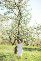 girl sniffing flowers / fresh spring flowers of apple, portrait of a girl in a beautiful spring garden