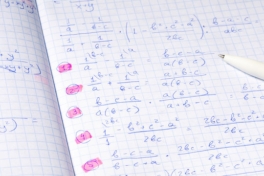 Algebraic Calculations In Open Graph Notebook With Black Pen. White Paper With Math Fractions. Notebook With Algebra Homework