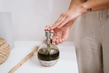 close up view of professional physiotherapist woman using oil ready to give a massage in clinic. Physiotherapy and body care concept