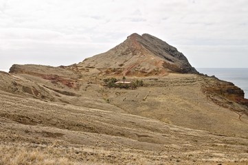 Isolated house with palms in a desertic place under a mountain peak (Madeira, Portugal, Europe)