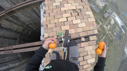 Riding a unicycle on top of a huge industrial construction, point of view shot, deep hole and abyss