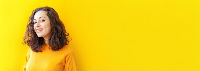 Happy girl smiling. Beauty portrait young happy positive laughing brunette woman on yellow...