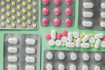 Pharmacy drugs, tablets in blister on a green background, painkillers and other medical products