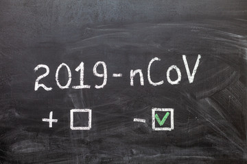 Fototapeta premium 2019-nCoV. The label and the boxes to tick on the chalk Board. Positive or negative. Coronavirus