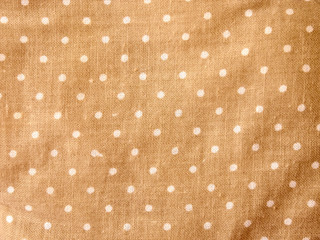 Light brown fabric close-up with white pea texture