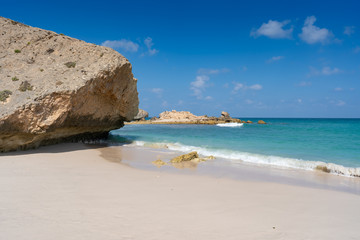 nice view on the lonely Fazayah Beach, Salalah Oman, Fantastic seascape, great outdoor scene of Beauty of nature concept background, blue sea, few clouds, light sandy beach, rocks in the water