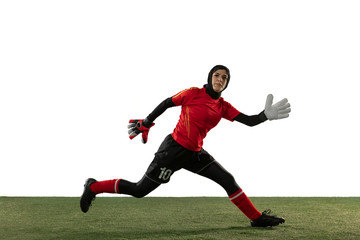 Arabian female soccer or football player, goalkeeper on white studio background. Young woman catching ball, training, protecting goals in motion and action. Concept of sport, hobby, healthy lifestyle.