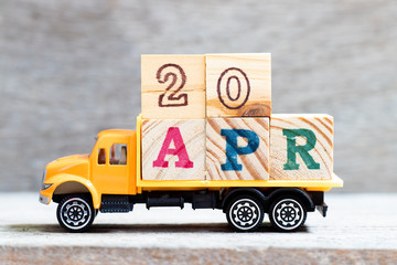 Truck hold letter block in word 20apr on wood background (Concept for date 20 month April)