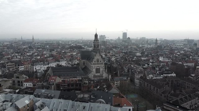 Slow aerial flight above antwerp city in direction saint paul cathedral on foggy day