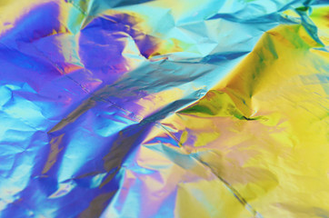 Holographic iridescent crumpled foil texture background
