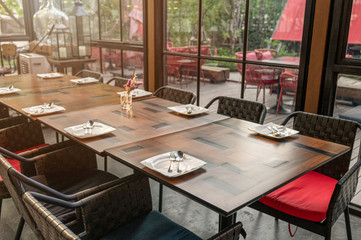Wooden dining table and chairs in industrial building at sunset
