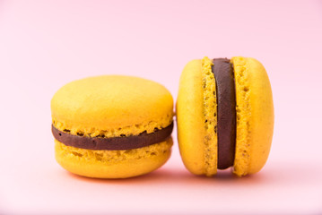 Tasty yellow french macarons on a pink pastel background. Close-up. Place for text.