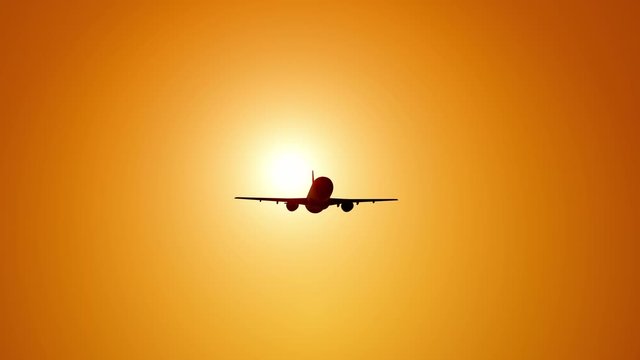 A large passenger plane takes off against the background of a sunset. Orange backgrand..Super slow motion.
