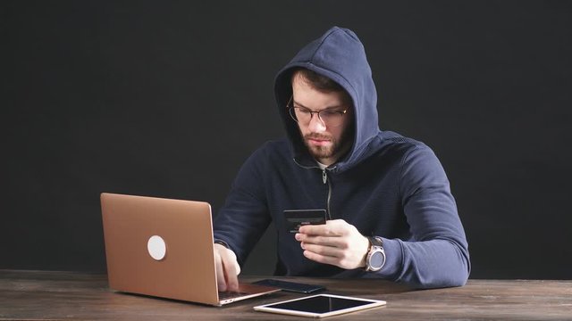 young dangerous hacker bandit engaged in crime, don't afraid of strangers, entered the room and hack laptop system, password. cyberattack nowadays. isolated in dark space
