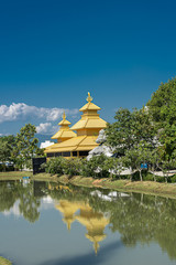 Yellow temple reflected in the lake in northern Thailand