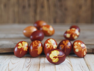 Easter eggs painted onion peel with a pattern of fresh herbs on a wooden ancient background. We color the eggs according to the old eco-friendly method with peeled onions.