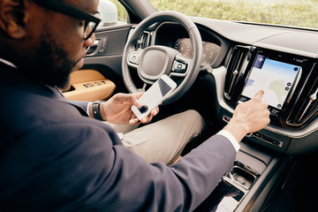 Close up of a driver using different devices he has in car.