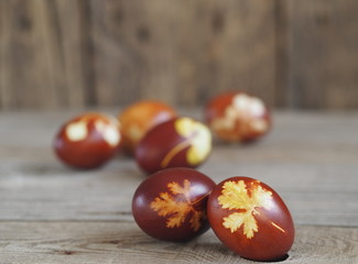 Obraz premium Easter eggs painted onion peel with a pattern of fresh herbs on a wooden ancient background. We color the eggs according to the old eco-friendly method with peeled onions.