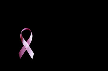 pink ribbon, a symbol of breast cancer awareness, isolated on a black background. space for text