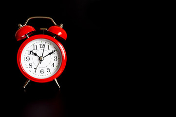 red round analog alarm clock isolated on black background. time 10:10. space for text