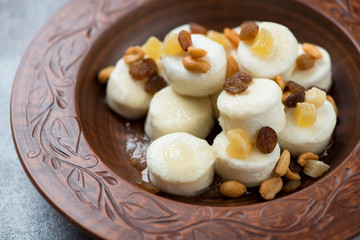 Closeup of steamed vareniki or dumplings made of cottage cheese in a clay plate, selective focus