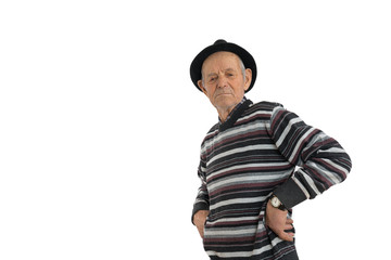 Pensive old man in casual clothes and black hat, thoughtful proud senior holds his hands on his waist, isolated over white background, copyspace for your text