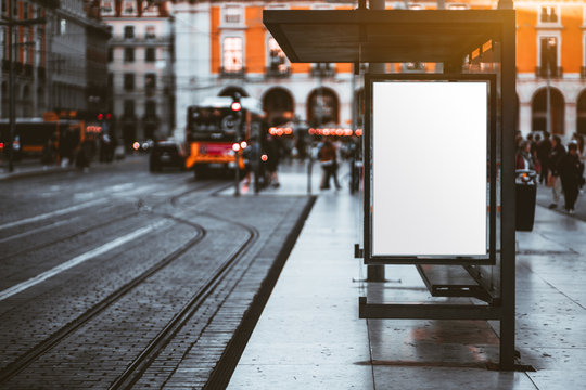 A Blank Advertising Billboard Placeholder Template On The City Street; An Empty Mock-up Of An Outdoor Poster On A Paved Tram Stop; A White Vertical Mockup Of An Urban Banner On The Bus Stop