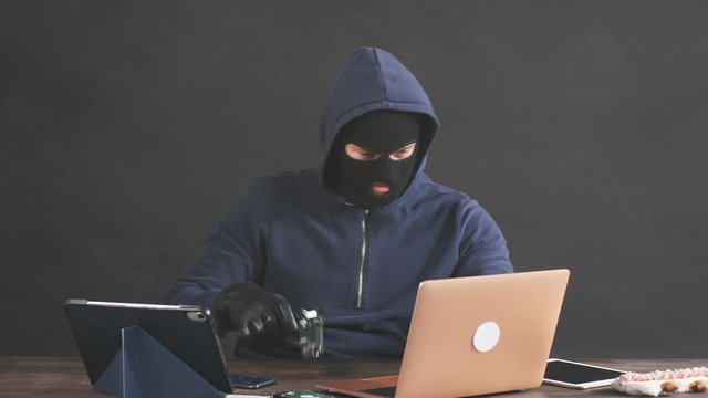 Hacker committing a crime with the aid of computers and information technology infrastructure, use gadgets for better hack. Cyberattack concept