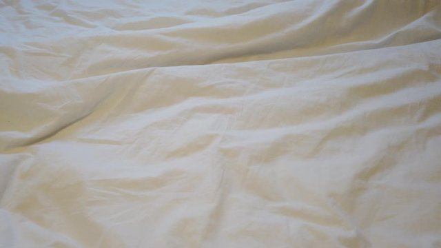 Crumpled white sheet on a double bed.