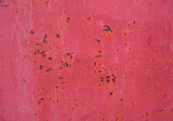 Bright pink metal surface with scratches and rust spots. Abstract background, texture.
