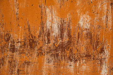 An old rusty metal surface with strips of orange paint. Abstract background, texture.