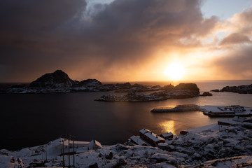 typical lofoten islands view. fishin town with mountains in backround. famous archipelago in north of norway. winter in wonderland. sunrise over typical and famous red cabins and fishermen's cabins.