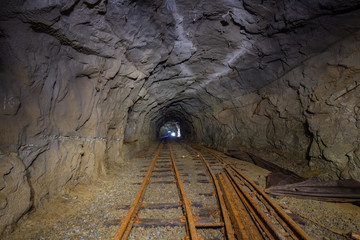 Old gold mine underground tunnel with rails